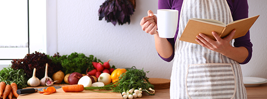 woman reading recipes in kitchen